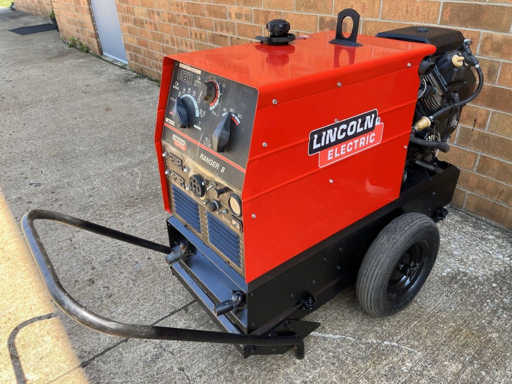 A red and black machine is on the sidewalk